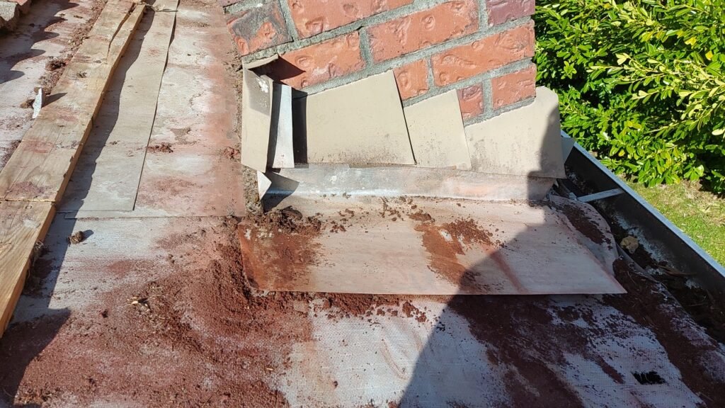 Original chimney back pan flashing that was too short and had no containment lip, on a Langley roof.