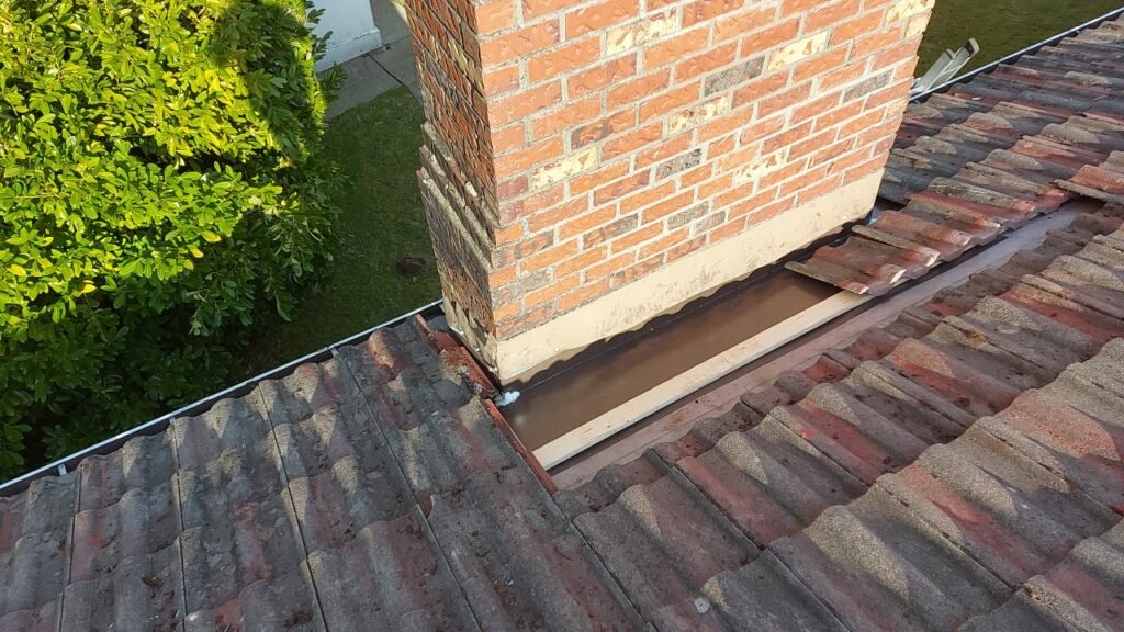 Concrete tiles reinstalled around a chimney with new pan flashing in Langley.