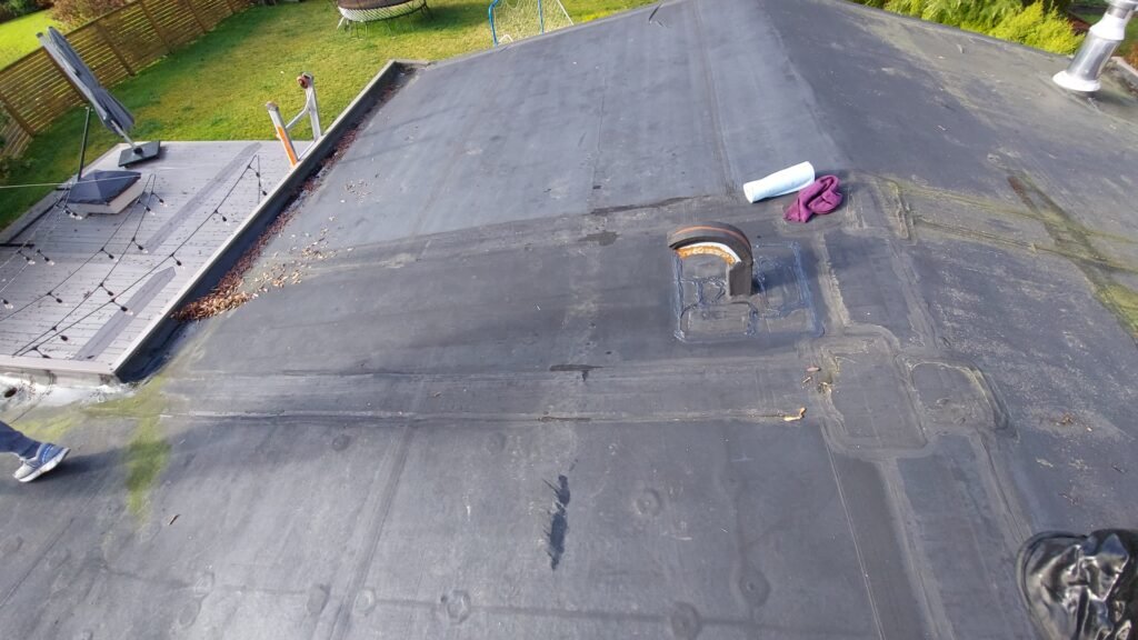 Sealing EPDM roof patches with EPDM caulking in North Vancouver.