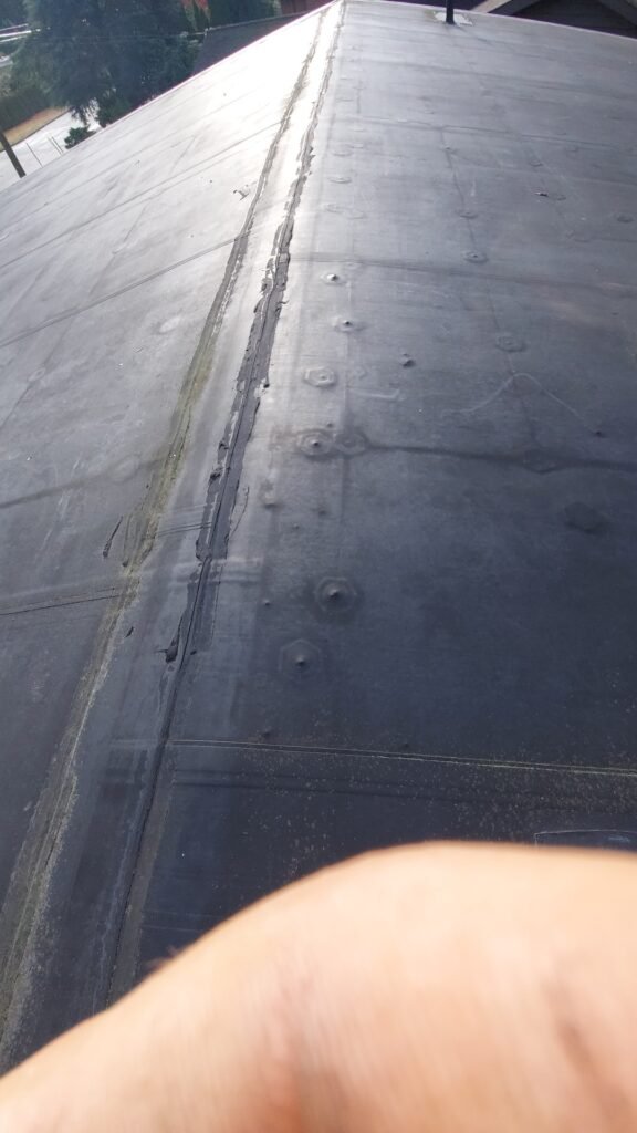 Screws backing out under an EPDM roof membrane in North Vancouver.