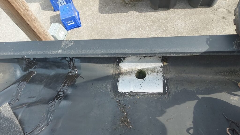 Commercial grade membrane patch applied beside an improperly installed gutter drain in Richmond.