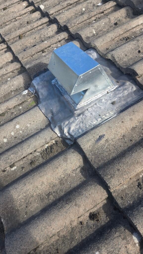 Metal gooseneck vent with a lead flange installed on S-shaped tiles in Vancouver.