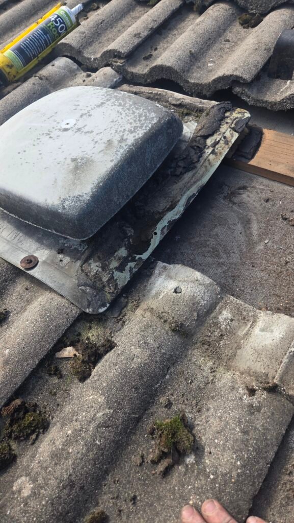 Old plastic roof vent on an S-tile roof in Vancouver with the tile lifted.