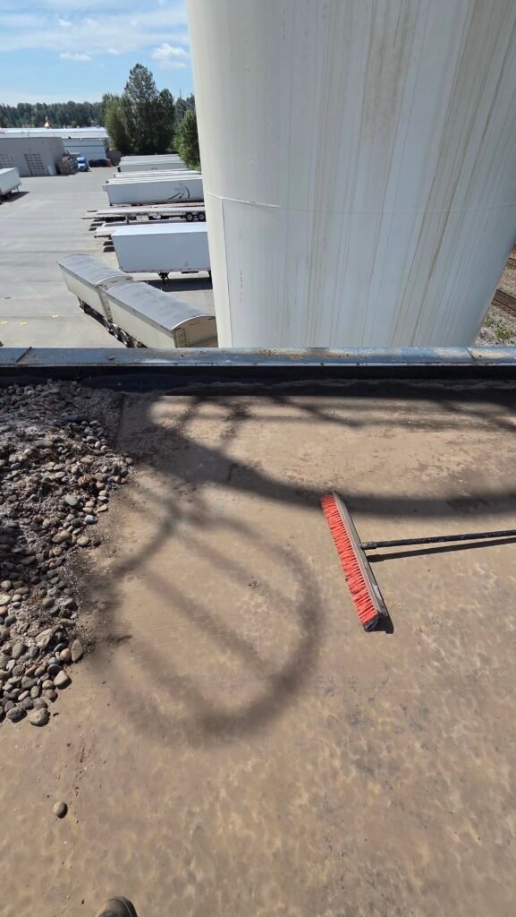 Commercial Flat Roof Leak Repair in Mission 7 A tiny puncture in the EPDM membrane in front of a broom, the small hole that caused the leak, in Mission.