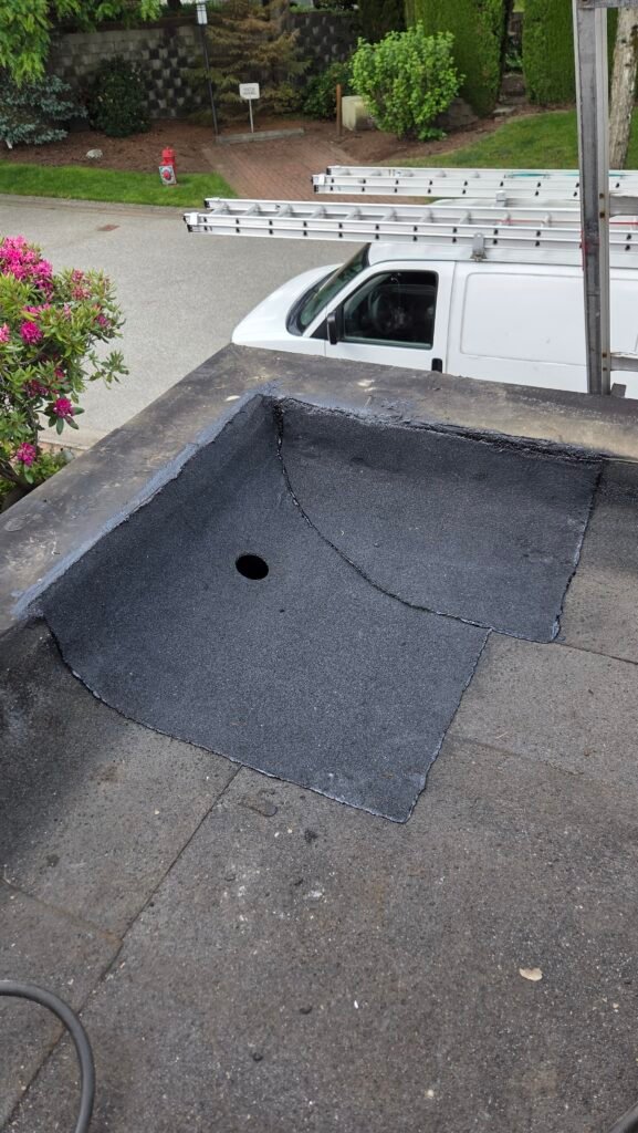 Finished two-ply torch-on patch around a new roof drain in New Westminster, no longer leaking.