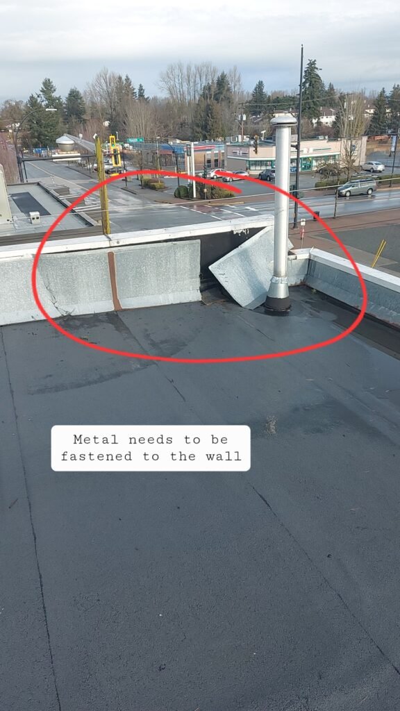Loose metal coping that needs fastening to the parapet wall on an Aldergrove flat roof.