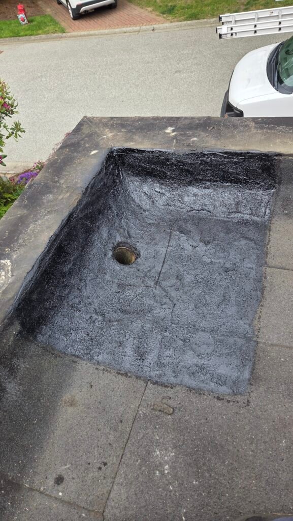 Prepping and embedding the granules on a torch-on roof around the drain before cutting, for fire safety, in New Westminster.