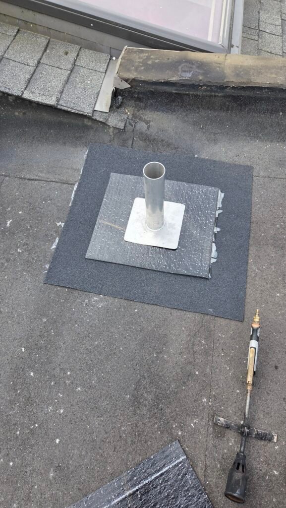 Two-ply torch-on patch, base layer and cap sheet, around a roof penetration in New Westminster.