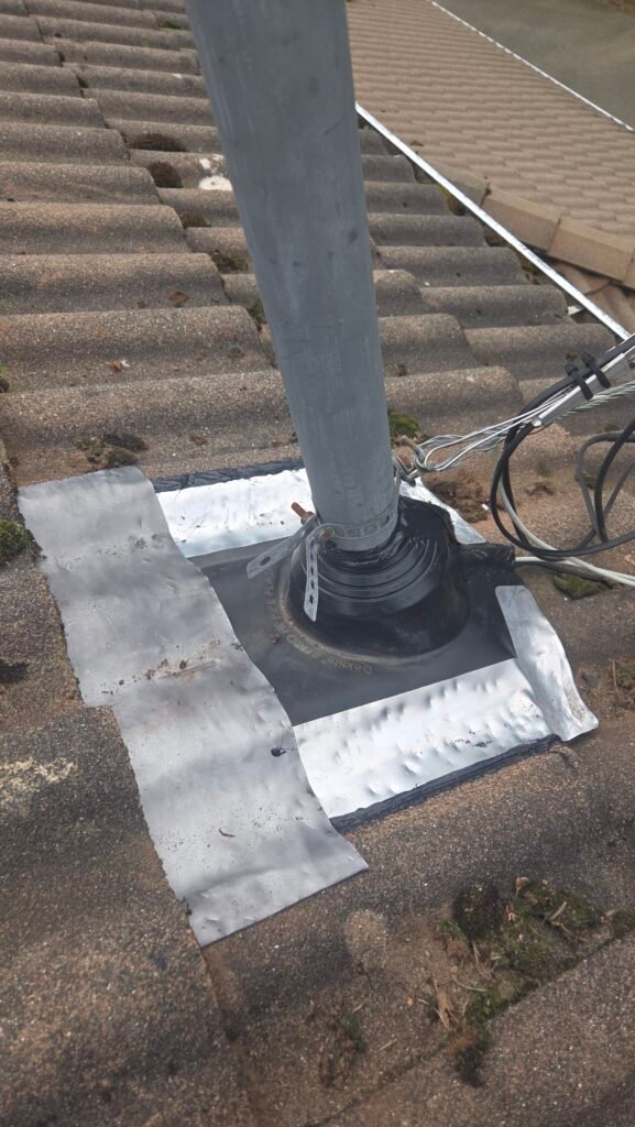 A new electrical mast flashing with a larger flange shaped to conform to the profiled tiles for a watertight fit, in Chilliwack.