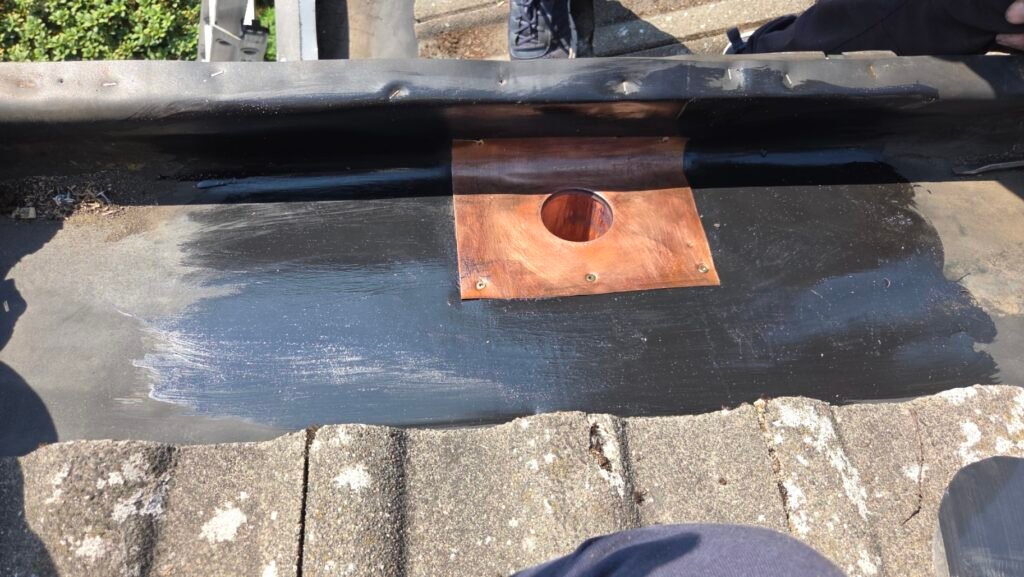 Hidden Gutter Drain Leak on a Coquitlam Tile Roof: Why the Drain Goes Over the Membrane 5 Bonding adhesive brushed onto the cleaned EPDM membrane around the new hidden gutter drain.