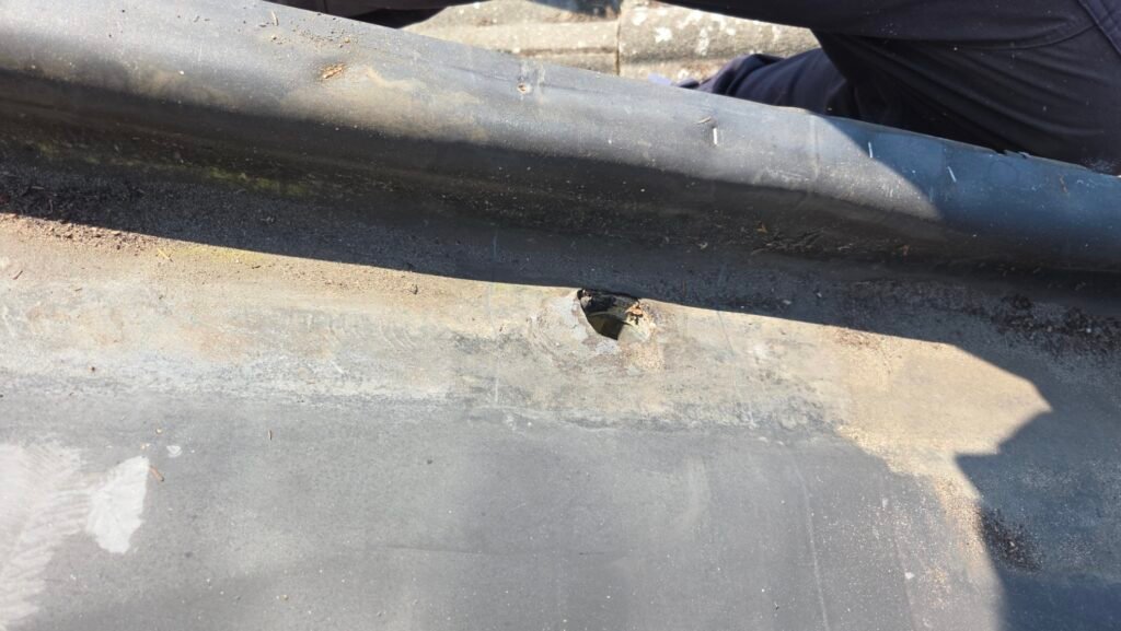Hidden Gutter Drain Leak on a Coquitlam Tile Roof: Why the Drain Goes Over the Membrane 1 Failed two inch drain in an EPDM hidden gutter on a Coquitlam tile roof, with old caulking around the flange.