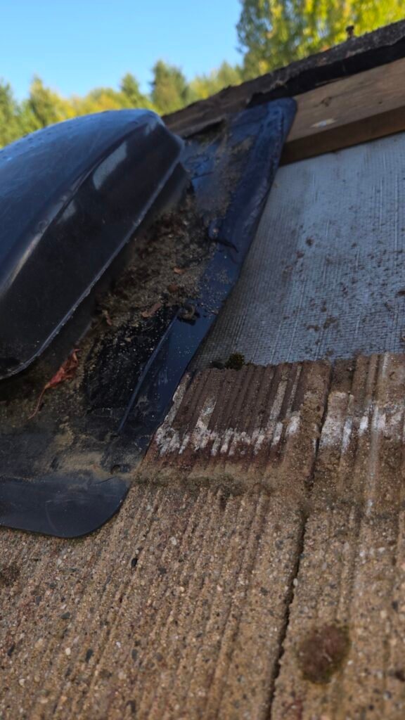 The tile beside the roof vent lifted away, showing where the roof mastic has let go of the plastic vent flange with some still stuck to the vent.