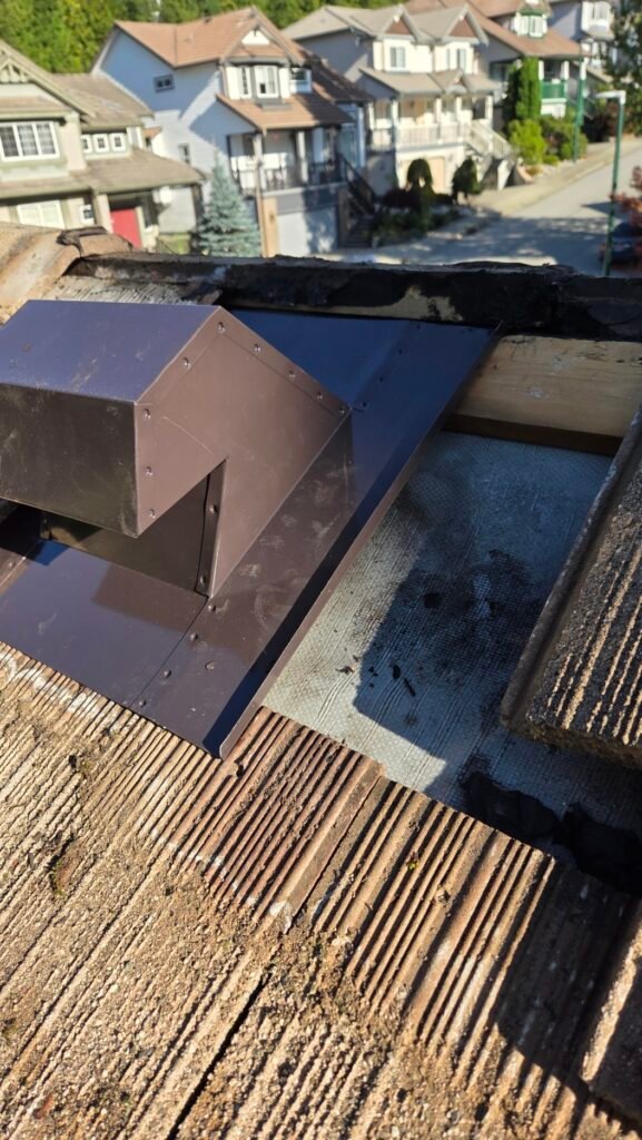 The replacement metal gooseneck roof vent going in, with a half inch lip bent up along the flange to divert water mechanically.
