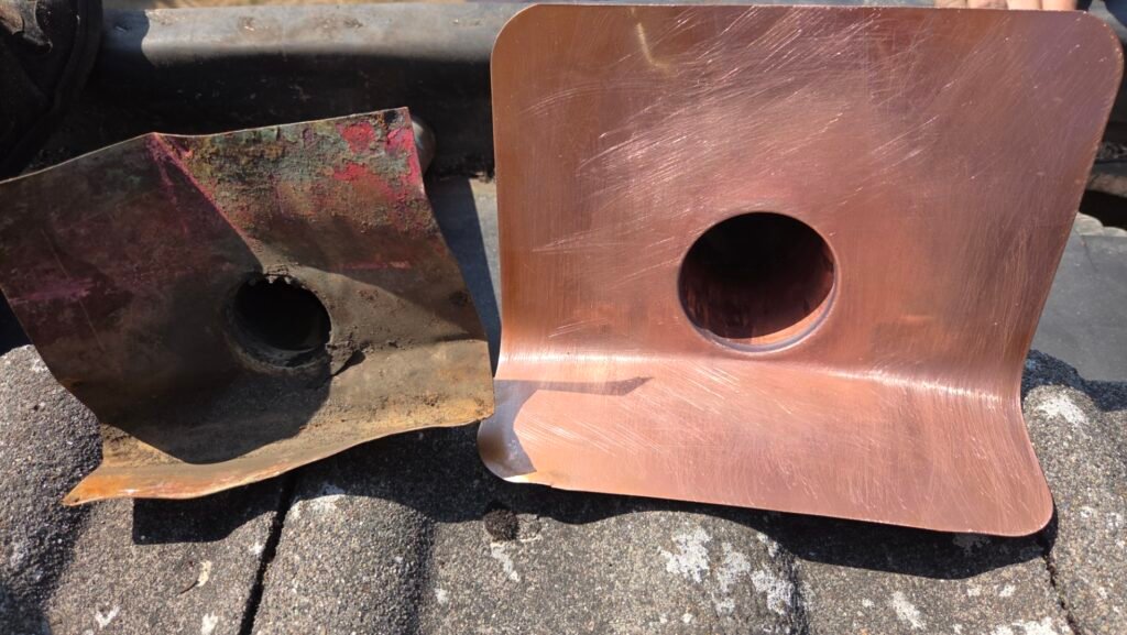 The removed two inch copper drain beside the new three inch drain, showing the difference in outlet size.